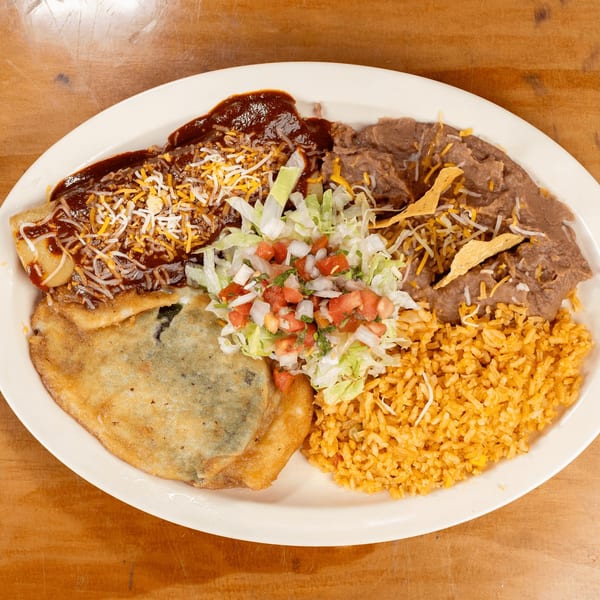 A Mexican combination plate with an enchilada, chile relleno, refried beans, rice, and salad.